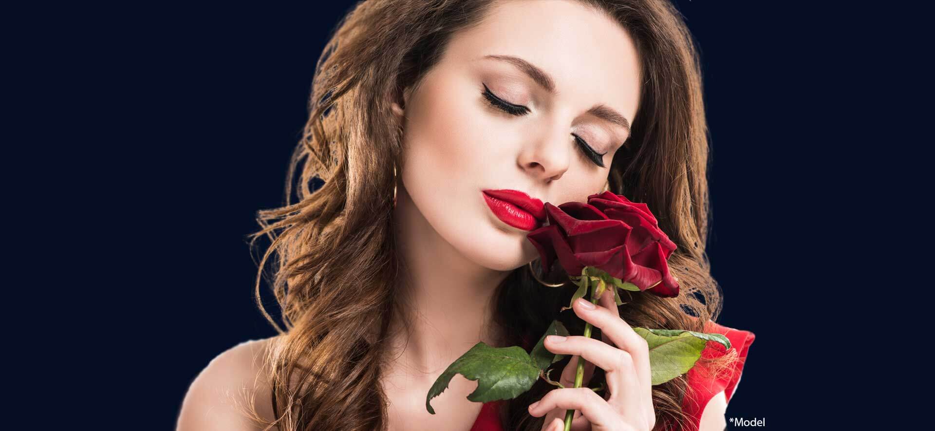 Stylish sensual girl touching face with rose isolated on dark background