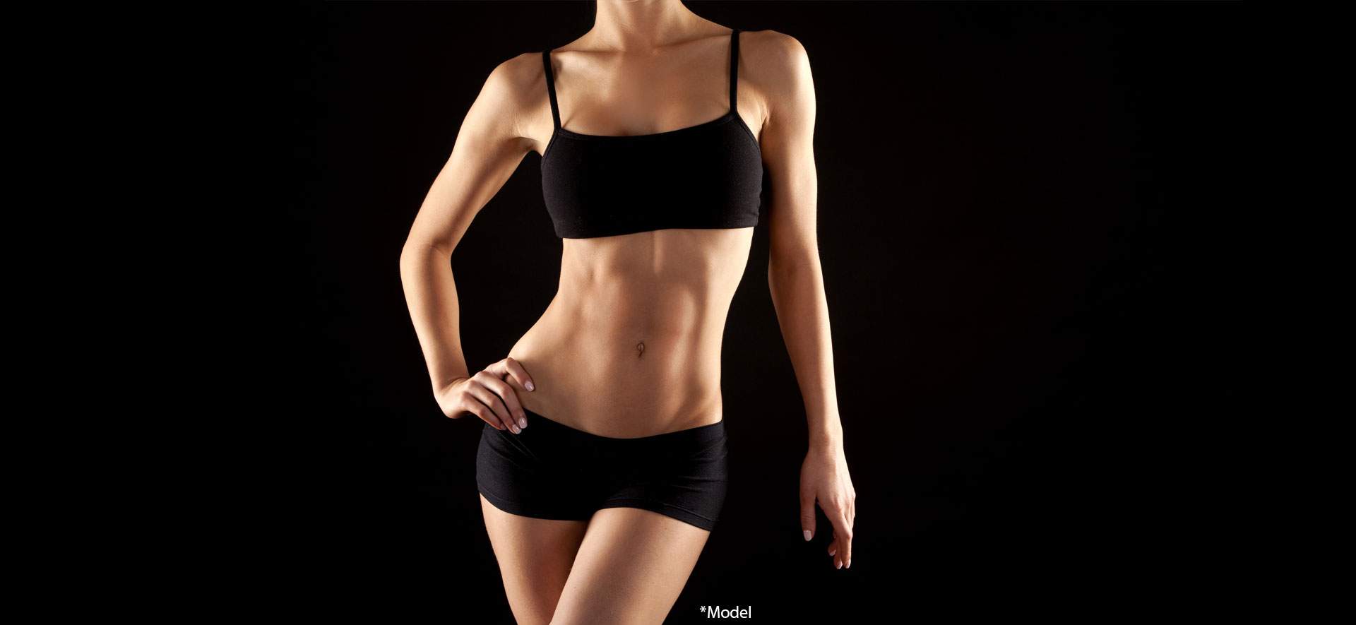 Female fitness model posing on black background